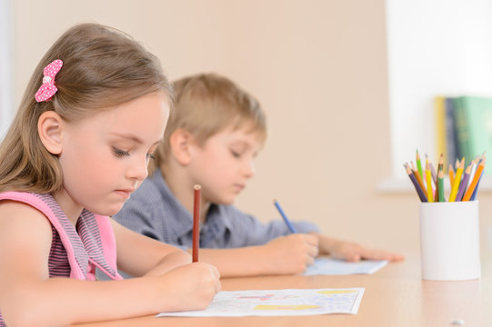Diligent young learners. Confident pupils writing something in t