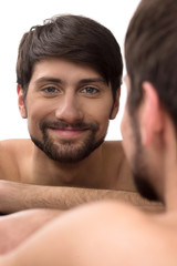 Obraz premium Man looking at mirror. Young man looking at himself at the mirro