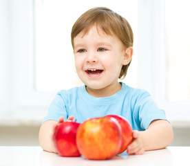 Fototapeta na wymiar Portrait of a happy little boy with apple