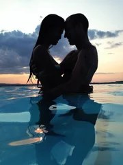 Zelfklevend Fotobehang couple at dusk in water © gmddl