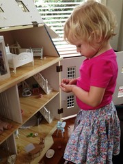 little girl playing with dollhouse