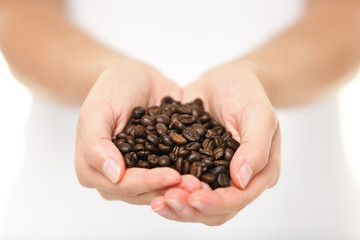 Coffee beans - woman showing coffee bean handful