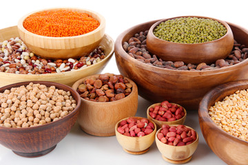 Different kinds of beans in bowls isolated on white