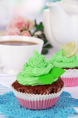 Beautiful cupcakes on dining table on room background