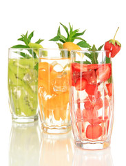 Glasses of fruit drinks with ice cubes isolated on white