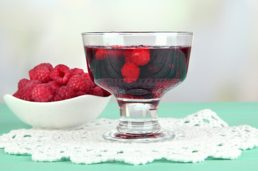 Jelly with fresh berries on green wooden table
