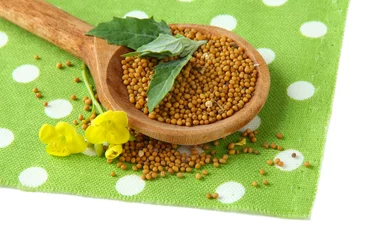 Zelfklevend Fotobehang Mustard seeds in wooden spoon with mustard flower isolated © Africa Studio