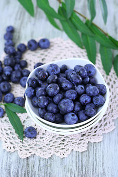 Blueberries in plates on napkin on wooden background