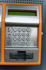 Orange Color Payphone using by call  close-up Number Pad