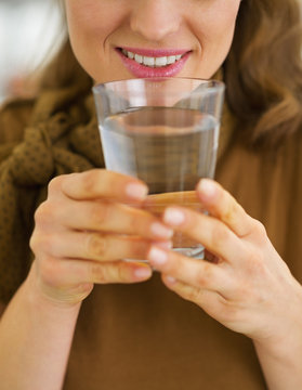 Closeup on woman drinking water in kitchen