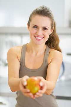 Smiling Young Woman Showing Mango