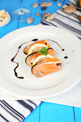 Mussels with sauce on plate on wooden table close-up