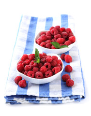 Ripe sweet raspberries in bowls, isolated on white