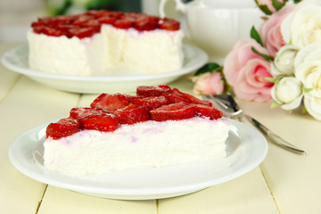 Cheesecake with fresh strawberry on white plate on wooden table