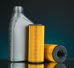 Car oil filters and motor oil can on dark color background