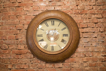 Large antique wooden clock on a brick wall, horizontal shot