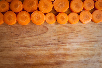 Chopped carrot circles  against wood