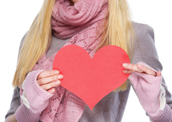 Closeup on heart shaped postcard in hand of teenager girl