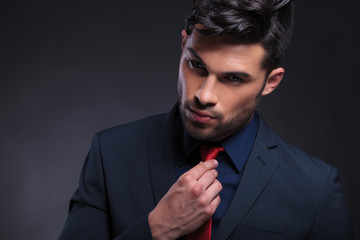 business man adjusts his tie