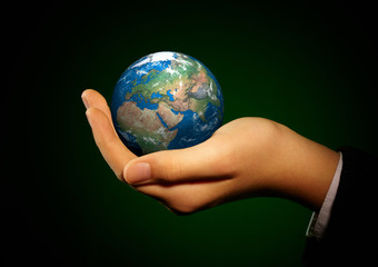 Hand of the person holds globe.