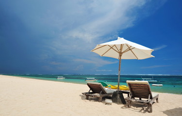 View of nice tropical empty sandy beach with beach chair