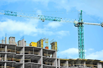 Crane and building construction site against blue sky