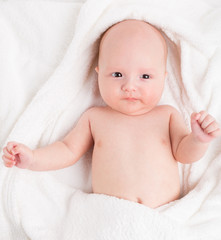 Cute baby wrapped into towels