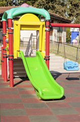 Green slide and blue swing in the park