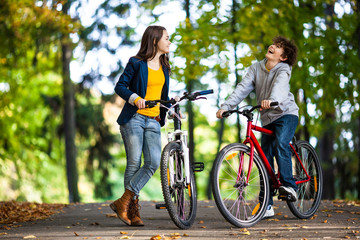 Urban biking - teens riding bikes in city park