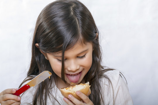 Ni&ntilde;a intentando probar un pan untado
