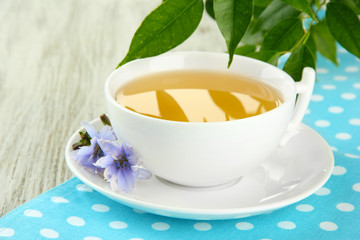 Cup of tea with chicory, on wooden background