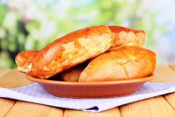Fresh baked pasties, on wooden table, on bright background