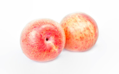 Ripe pink pluots on white background.