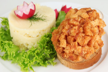 Chicken Kiev on croutons with mashed potatoes, isolated on