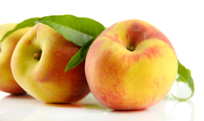 Ripe sweet peaches with leaves, isolated on white