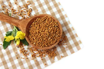 Poster Im Rahmen Mustard seeds in wooden spoon with mustard flower isolated © Africa Studio