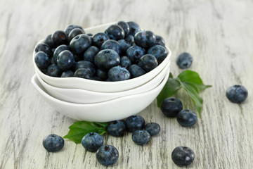 Blueberries in bowls on wooden table