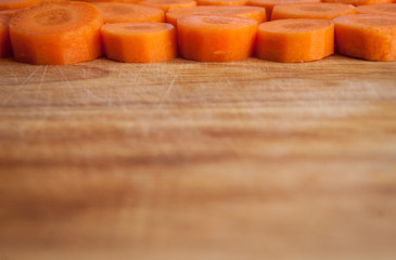 Chopped carrot circles  against wood