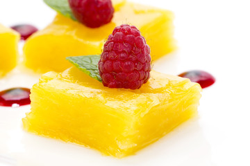 dessert of pineapple and decorated with raspberries on a white background