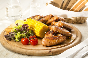 chicken wings are grilled on a wooden platter