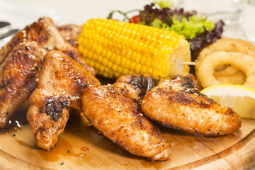 chicken wings are grilled on a wooden platter