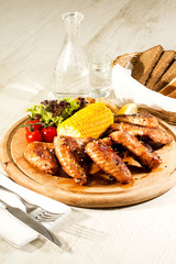 chicken wings are grilled on a wooden platter