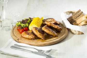 chicken wings are grilled on a wooden platter