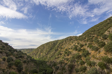 Fototapeta na wymiar Deep valley between mountains during the summer dry