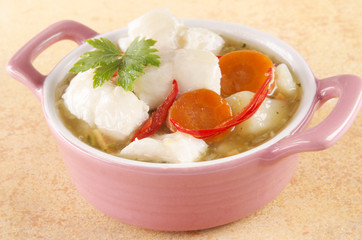 white fish stew in a pink bowl