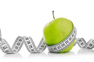 Measuring tape wrapped around a green apple