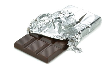 A bar of chocolate in tin foil wrapper on white background