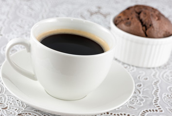 Coffee cup and chocolate muffin on the table