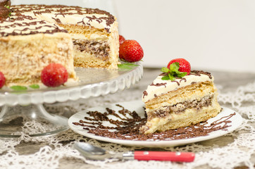 Homemade nutty cake with strawberries and slice of cake