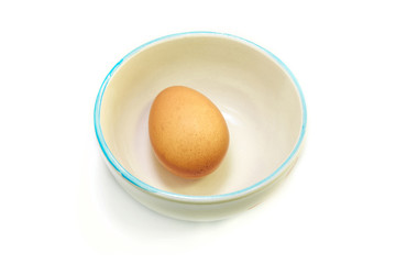 The egg in ceramic bowl with isolated white background